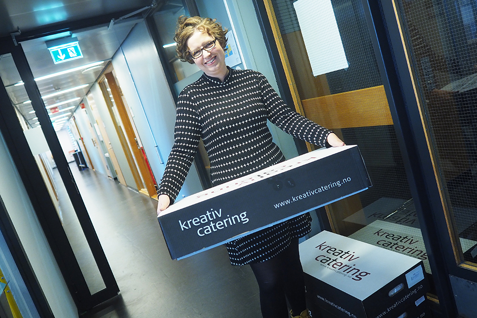 Kvinne står med cateringboks med tekst "kreativ creating". 